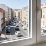 Vista desde el interior de un piso en Zaragoza a través de una ventana de PVC hacia una calle con tráfico